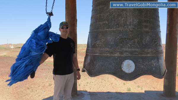 our customer is standing with huge bell of Khamar Monastery