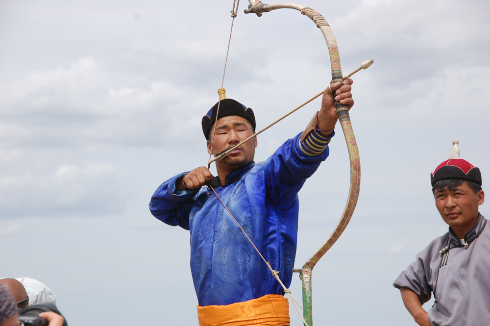 Mongolian archer is going to release the arrow in the Naadam Festival competition