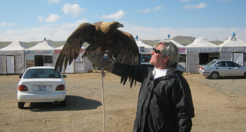 A customer from USA takes a photo with an eagle